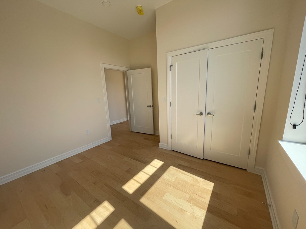 a bedroom with two closets and a wood floor
