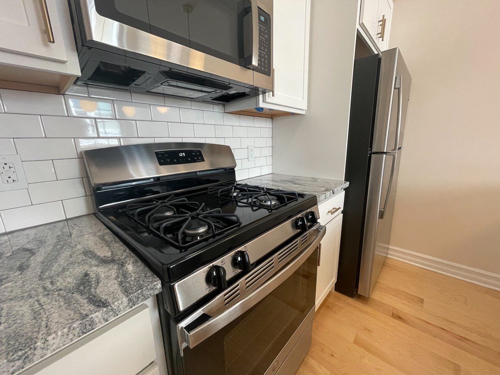 an empty kitchen with a stove and a refrigerator