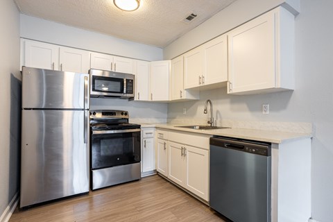 A kitchen with white cabinets and stainless steel appliances.