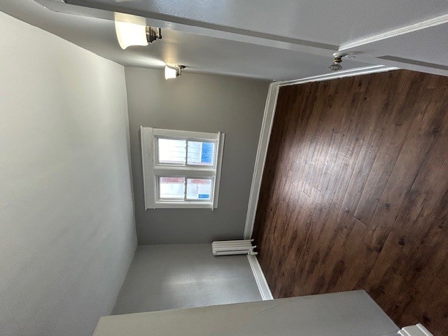 an empty hallway with a wooden door and a window