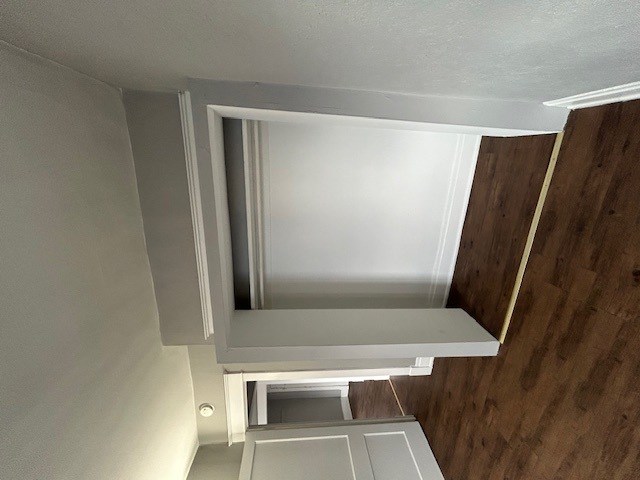 a white cabinet with a mirror in a small room