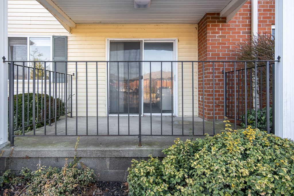 A house with a black iron fence and a brick wall at Centerpointe Apartments, Canandaigua, NY, 14424