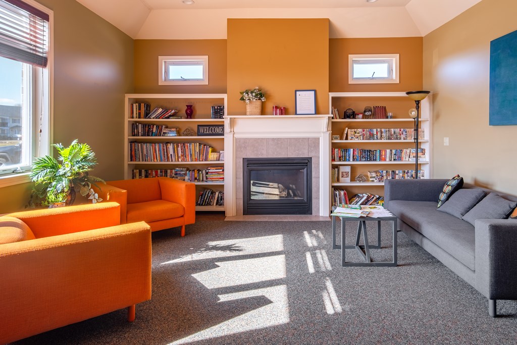 A living room with a fireplace and a bookshelf at Centerpointe Apartments, Canandaigua, NY