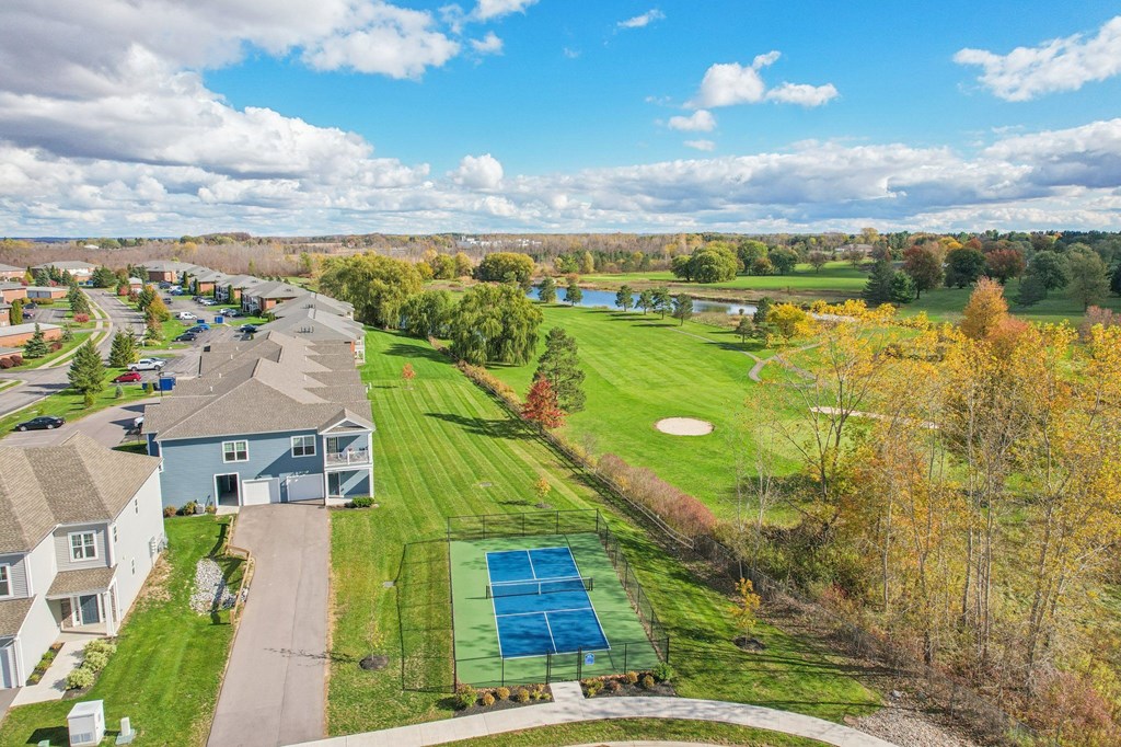 A view of a residential area with a tennis court.