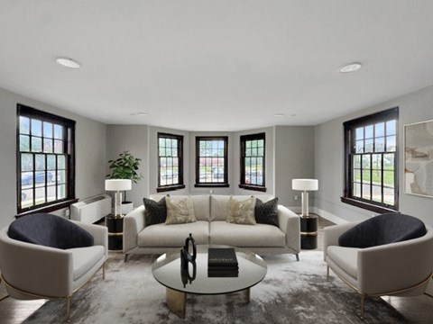 A modern living room with a large sofa, two chairs, and a coffee table.