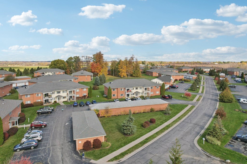 A large building complex with a parking lot in front.