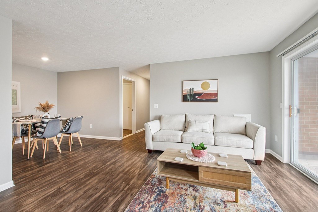 A living room with a white couch and a wooden coffee table.