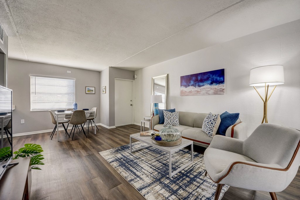 a living room with a couch and chairs and a dining room table