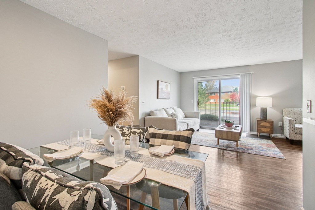 A dining room with a glass table set for two.
