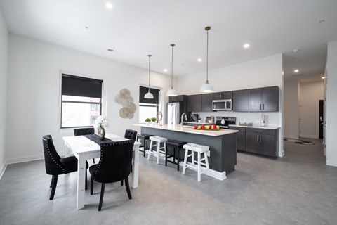 A modern kitchen with a dining table and chairs.