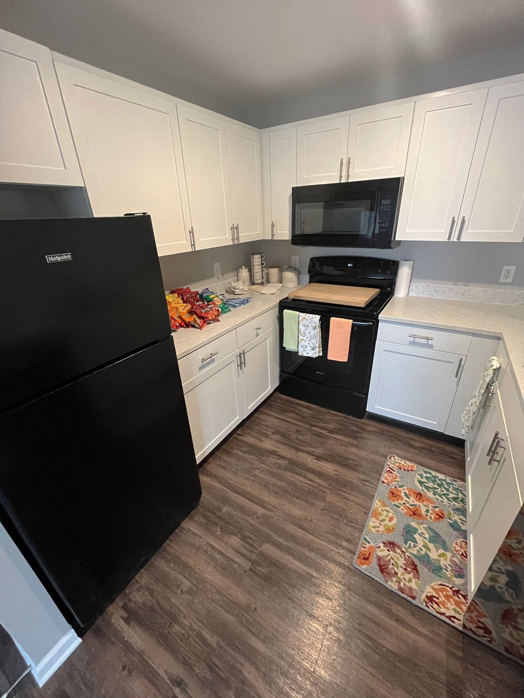 a kitchen with white cabinets and black appliancesat Centerpointe Apartments, Canandaigua