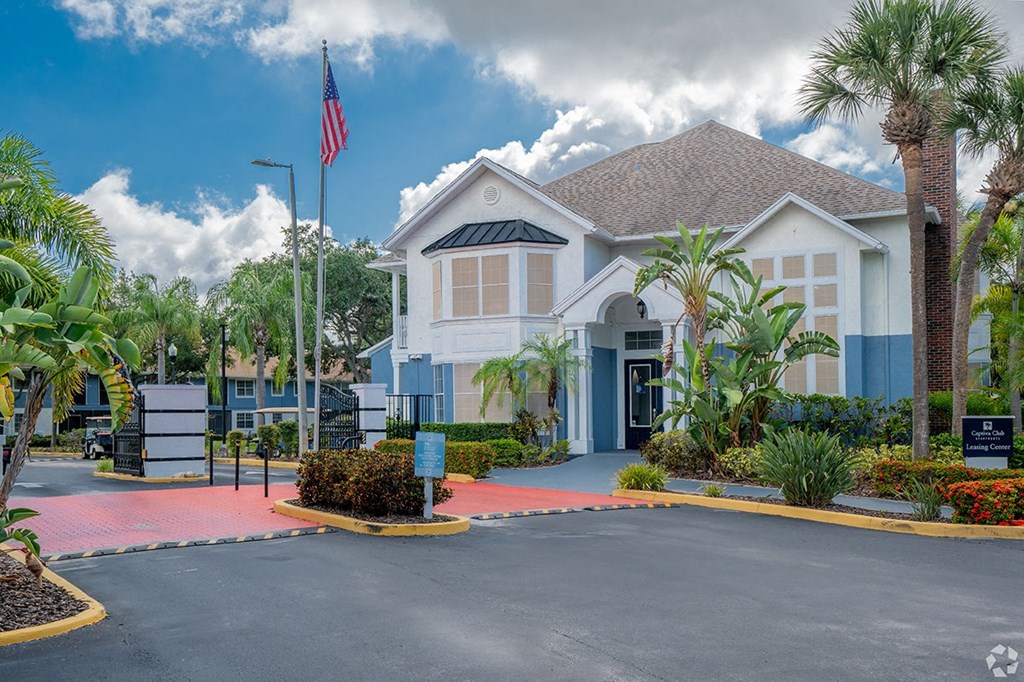 a house with a driveway and an flag inExterior at Captiva Club Apartments at 4401 Club Captiva Drive in Tampa, Florida 33615 front of it