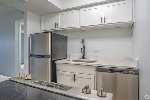 a kitchen with stainless steel appliances and white cabinets