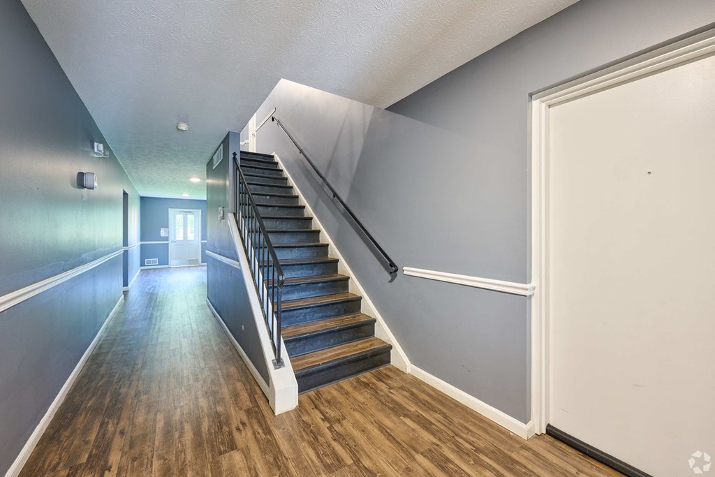 a staircase in a home with wood floors and blue walls at Centerpointe Apartments, Canandaigua