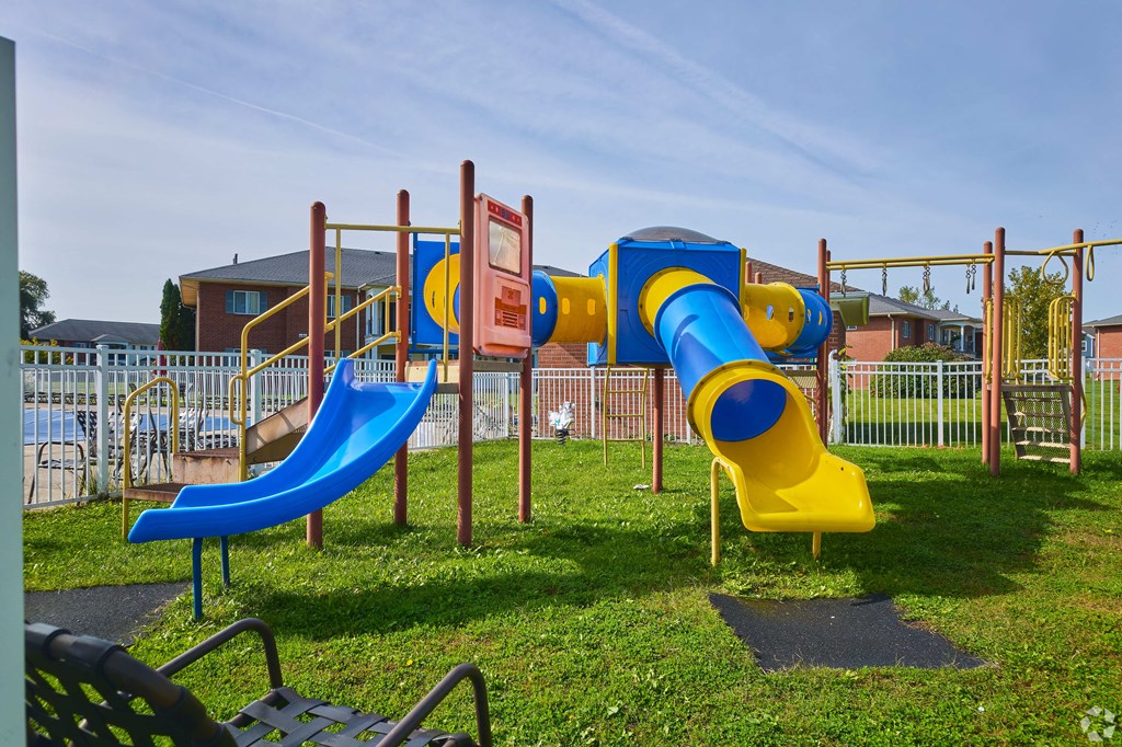 a playground with slides and other toys in a park at Centerpointe Apartments, New York
