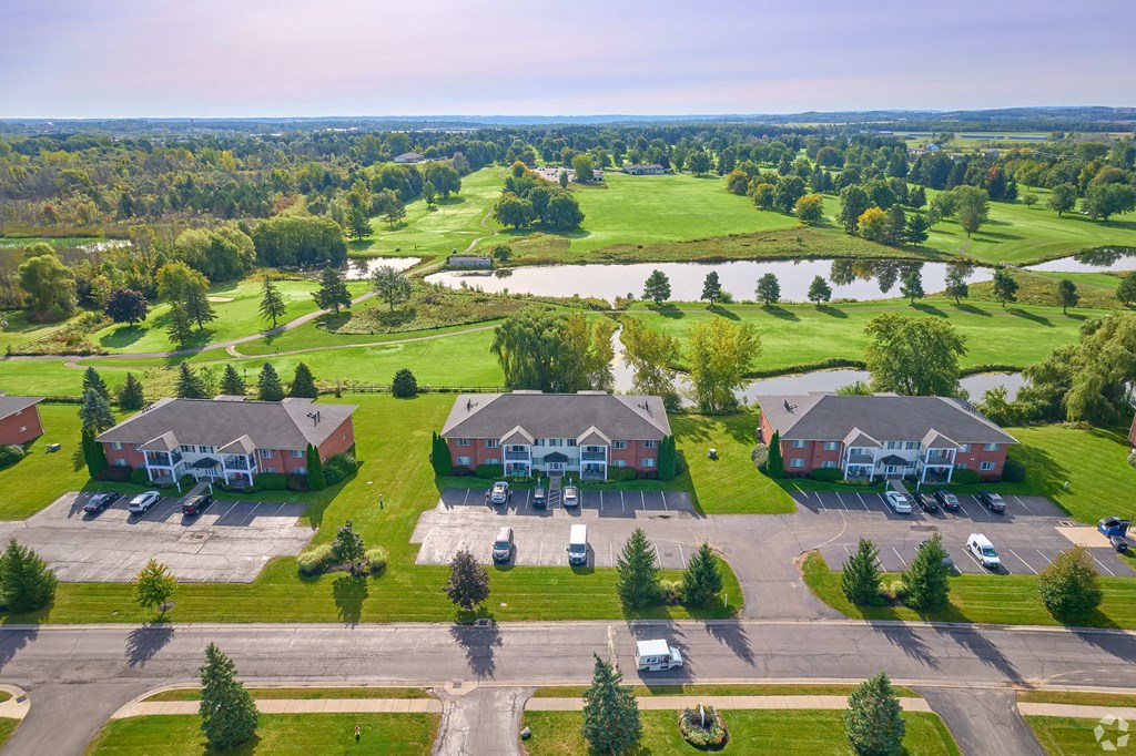 an aerial view of a neighborhood of houses with cars parked in front of a field at Centerpointe Apartments, New York, 14424