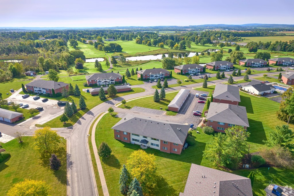 an aerial view of a neighborhood of houses and yards with green grass and trees at Centerpointe Apartments, Canandaigua