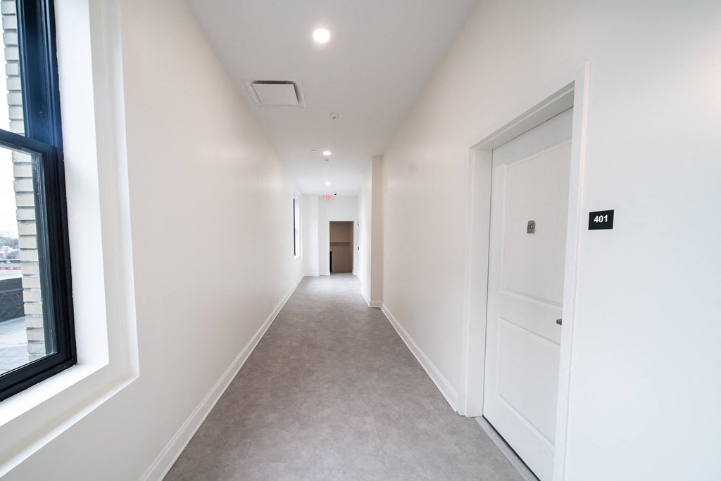 a corridor in a building with white walls and white doors