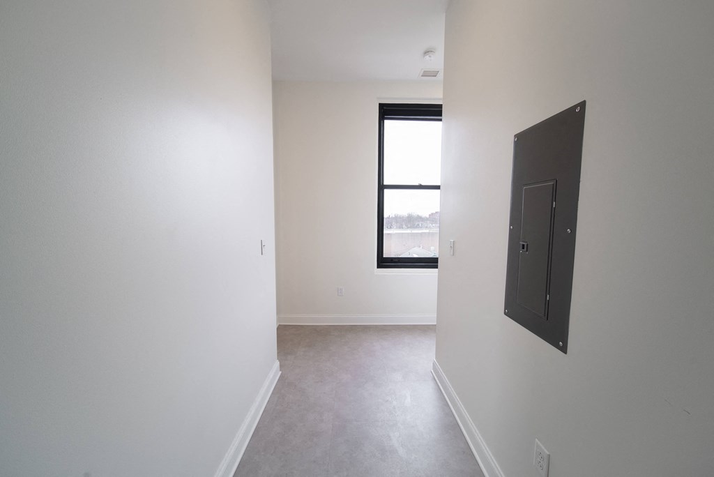 an empty room with a window and a white wall