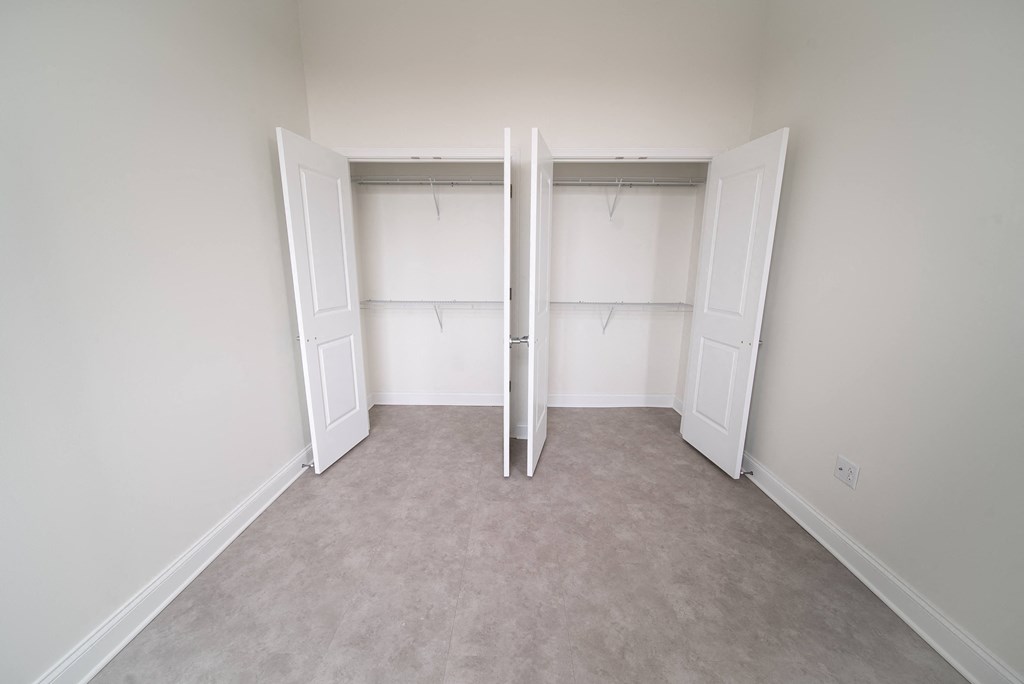 an empty closet in a home with white walls and doors