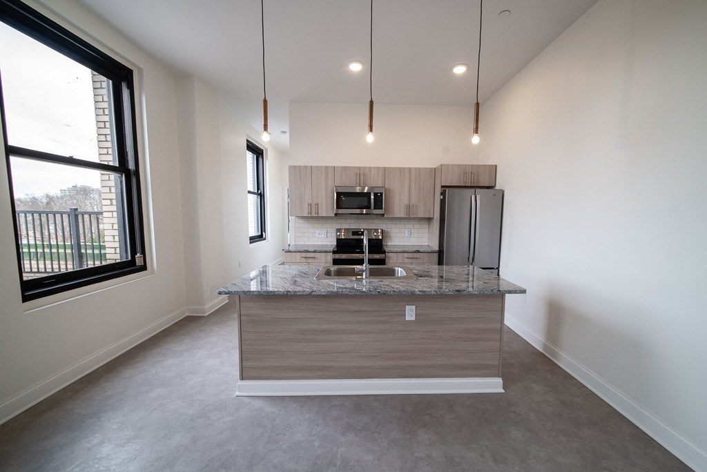 a kitchen with a granite counter top and a stainless steel refrigerator