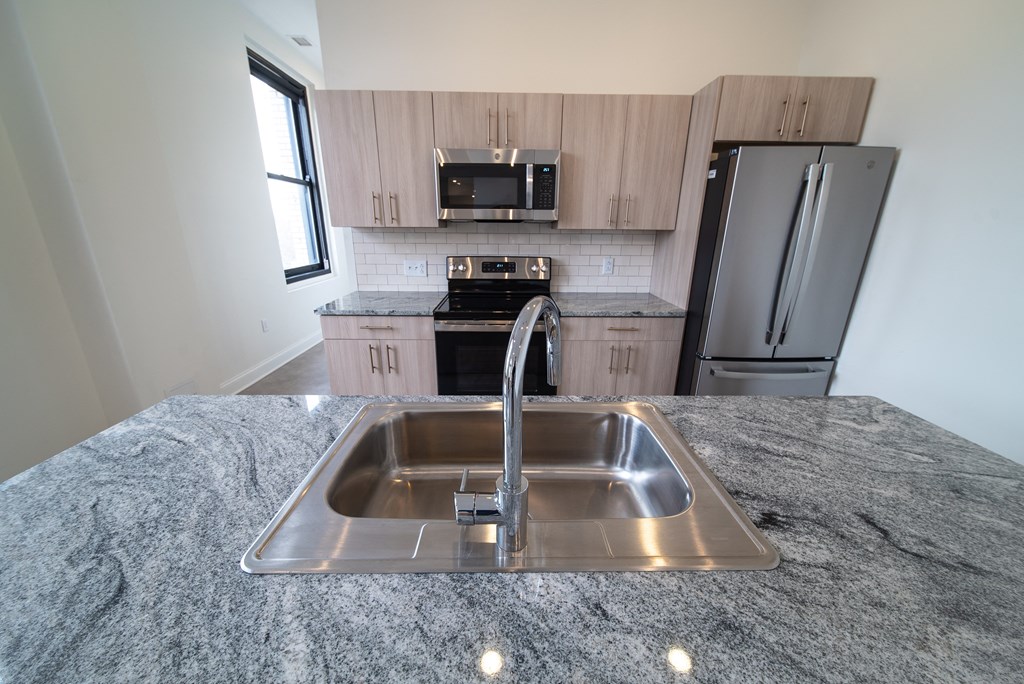 a kitchen with granite counter tops and a stainless steel sink