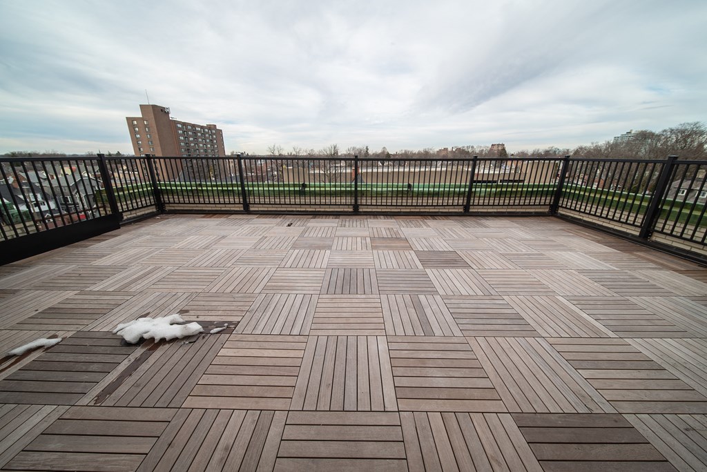 a large balcony with wooden floors and a city skyline in the background