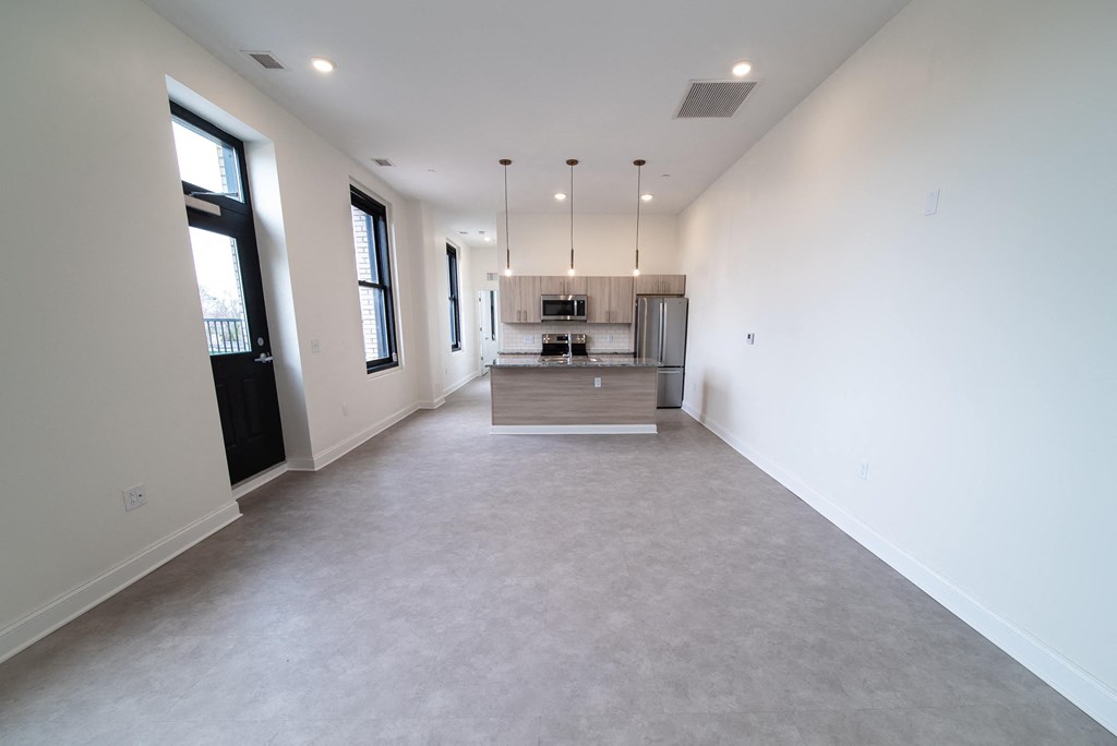 an empty living room with a kitchen in a new home