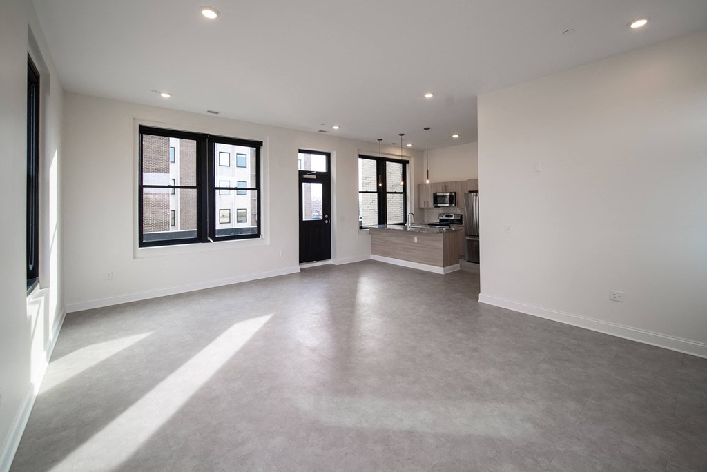 the living room and kitchen of a new home with no furniture