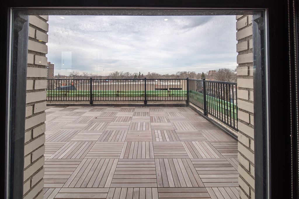 a balcony with a view of a field and a fence