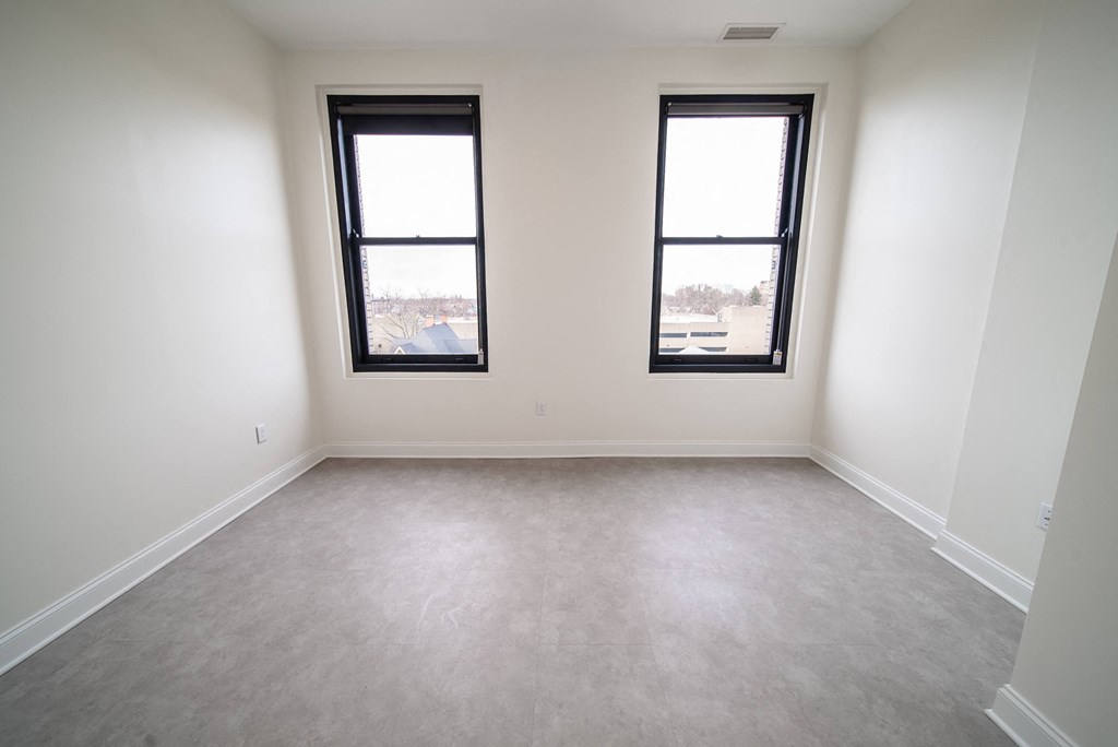 an empty room with two windows in it