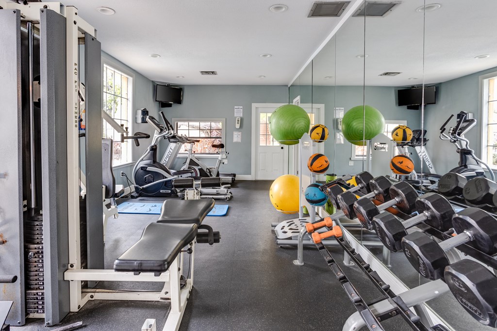 A gym with a variety of equipment including treadmills, weight machines, and dumbbells at Centerpointe Apartments, Canandaigua, NY, 14424