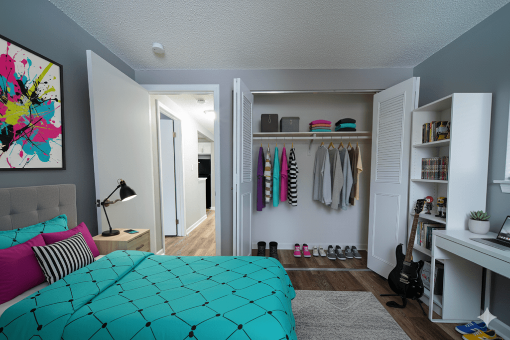 A room with a bed, a guitar, a bookshelf and a painting on the wall.