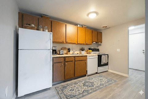 A kitchen with wooden cabinets and a white refrigerator. at Willowbrooke Apartments & Townhomes, Brockport, NY, 14420