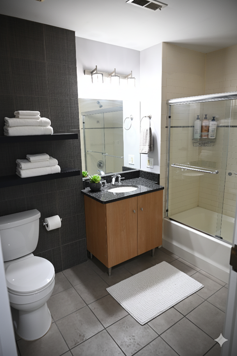 A bathroom with a toilet, sink, and shower.