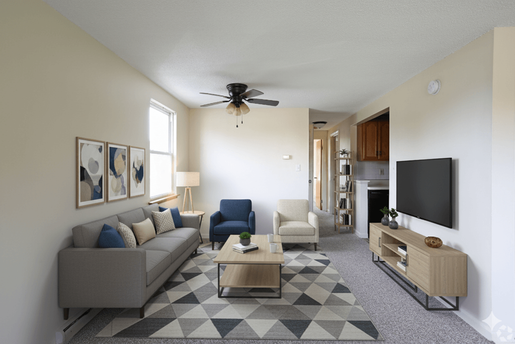 A living room with a grey couch, a blue chair, a coffee table, and a television.