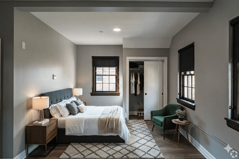 A bedroom with a large bed and a green chair.
