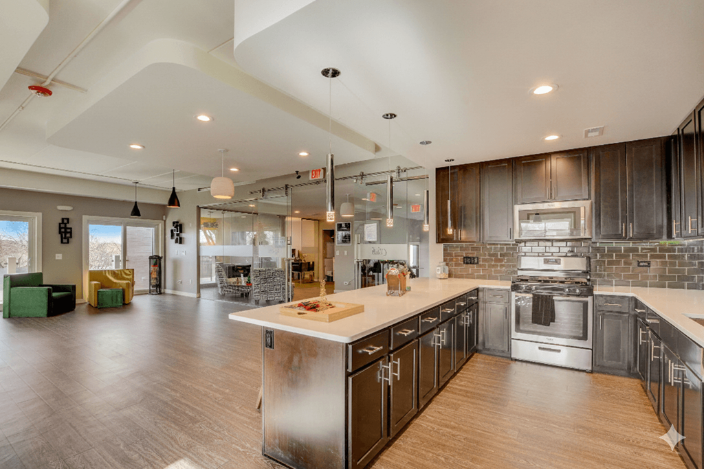 A modern kitchen with dark wood cabinets and a large island.