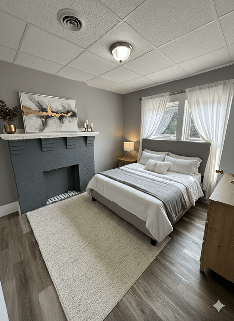 A bedroom with a fireplace and a bed.