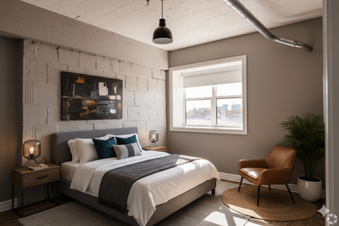 A bedroom with a large bed and a chair.