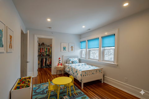 A white bedroom with a white bed and a yellow table.