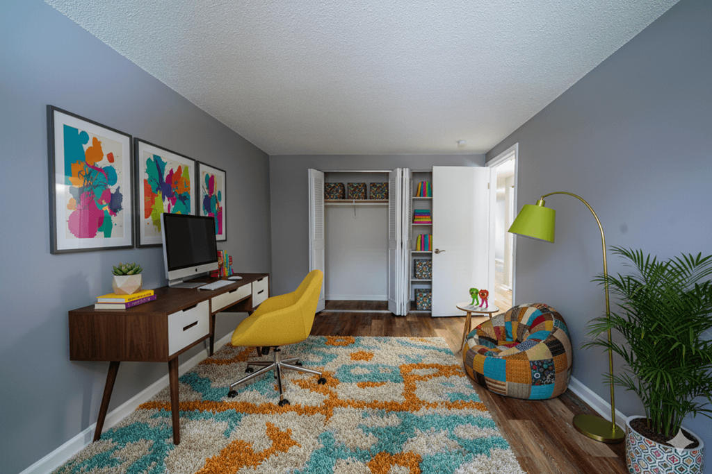 A room with a desk, chair, and a rug.