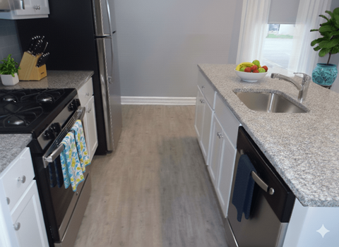 A kitchen with a black stove top oven and white cabinets.