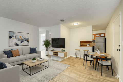 A living room with a grey couch, a coffee table, a television, and a dining table with chairs.