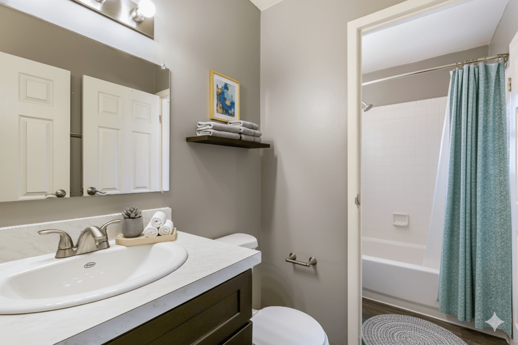 A bathroom with a white sink and a white toilet.