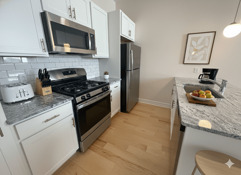 A kitchen with white cabinets and a granite countertop.