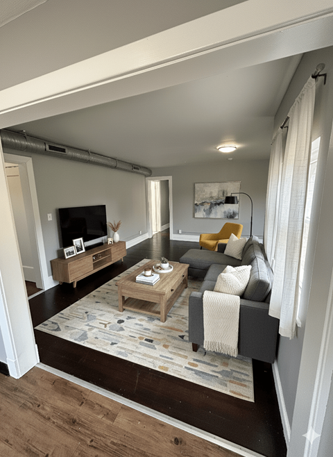 A living room with a grey couch and a coffee table.