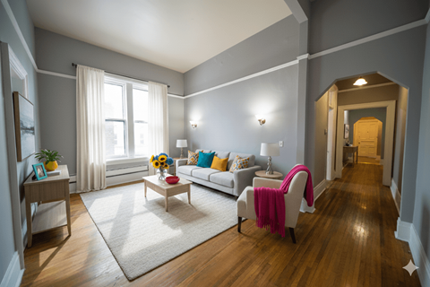 A living room with a white couch and a pink blanket.