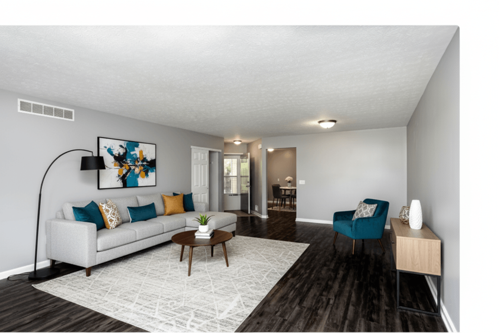 A living room with a white couch, a blue chair, and a coffee table.