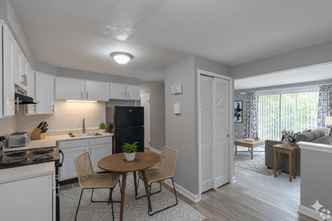 A kitchen with a table and chairs in the middle of the room.